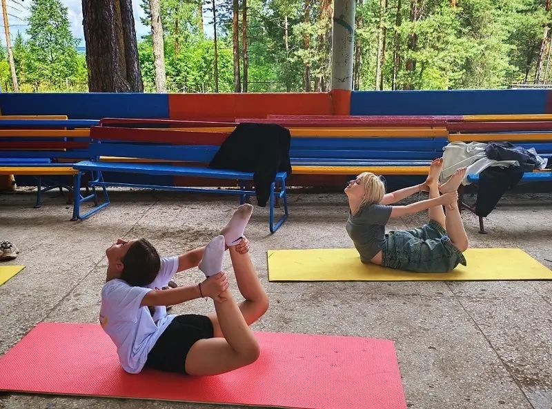 Не дежурная утренняя зарядка, а йога — разминка, дающая телу гибкость и выносливость, помогающая плавно войти в бодрый режим летнего дня в загородном лагере